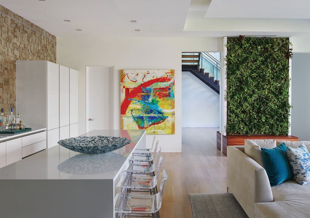 A natural wall of green and abstract art are standout design features of the home’s lower level. PHOTOGRAPHED BY ANICE HOACHLANDER