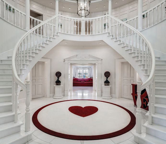 A twin staircase leads to a marble-lined foyer PHOTO COURTESY OF LONG & FOSTER